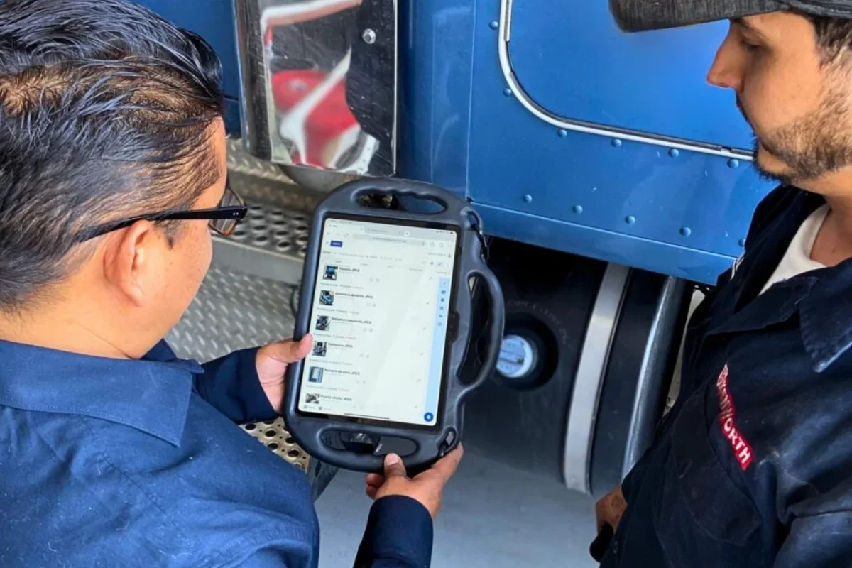 Technicians reviewing SITIC Software ERP on a tablet while inspecting a unit